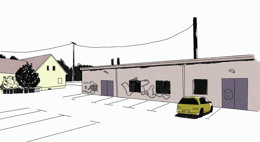 Ein flacher Garagenbau, davor ein einzelnes geparktes gelbes Auto