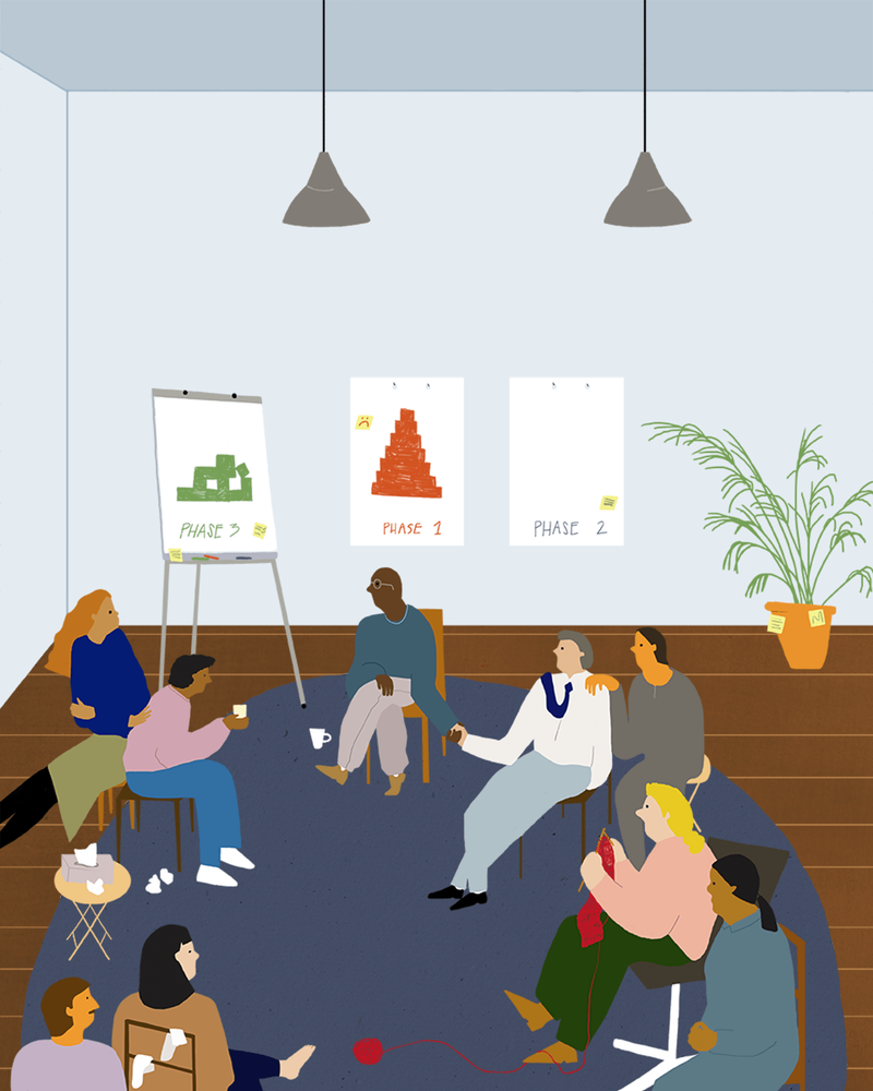 Eine Gruppe von Menschen in einem Stuhlkreis vor Flipcharts